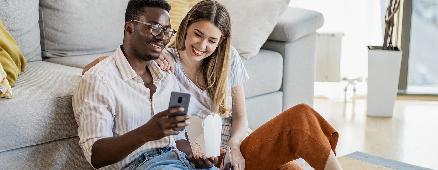 man and woman sitting on the floor on the phone